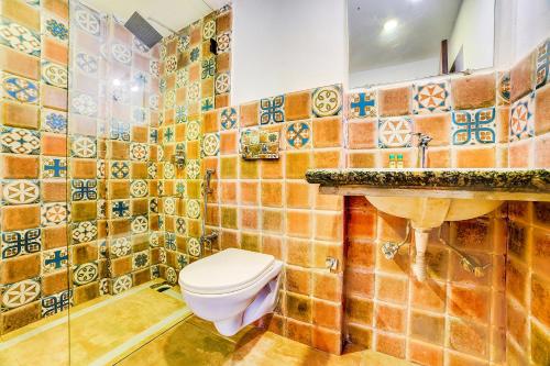 a bathroom with a toilet and a sink at Nitya Resort, Calangute in Calangute