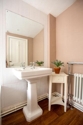 a bathroom with a white sink and a mirror at 14 Market Cross Place - Beachfront location with lovely sea views - Aldeburgh Coastal Cottages in Aldeburgh