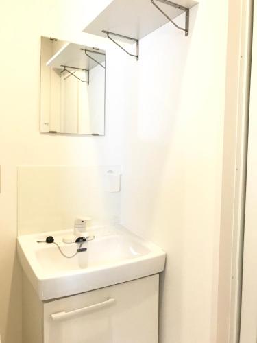 a white bathroom with a sink and a mirror at ROSE ROOM in Fukuyama