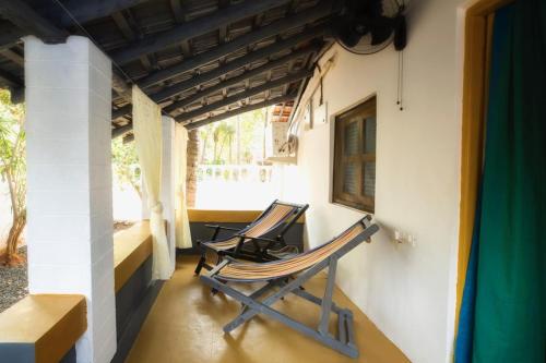 two rocking chairs sitting on a porch of a house at Craft Hostels in Anjuna