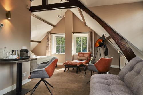 a room with chairs and a table in a attic at Fort Resort Beemster in Zuidoostbeemster