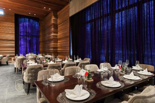 a dining room with tables and chairs and blue drapes at Grand Cosmos Resort Ruisui Hualien in Ruisui