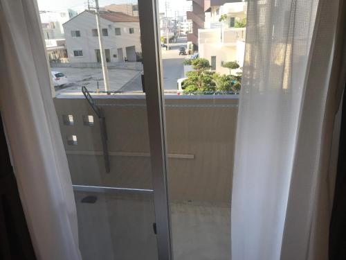 an open window with a view of a city at Weekly Harbourview Mansion Ginowan in Ginowan