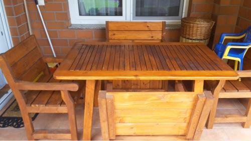 una mesa y sillas de madera y una mesa y sillas de madera en Galerius Apartment, en Siófok