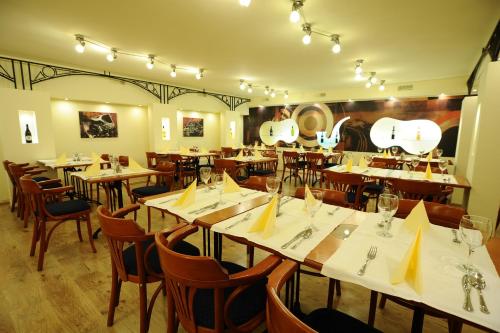 un restaurante con mesas de madera y sillas con servilletas amarillas en Hotel Minaret&Étterem, en Eger