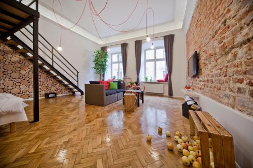 una gran sala de estar con una pared de ladrillo en City Vibes Apartments, en Cracovia