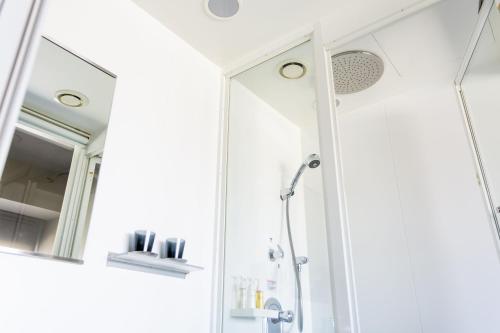 
a bathroom with a shower, sink, and mirror at remm Shin-Osaka in Osaka
