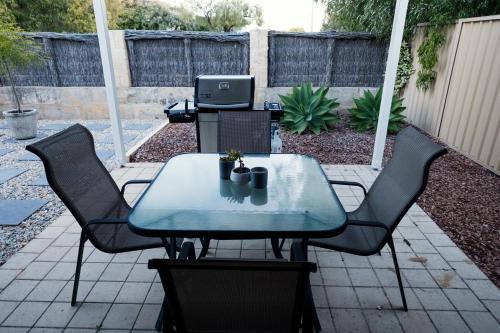 a table and chairs in a backyard with a tv at FortyTwo - Oceanside Retreat Busselton in Busselton