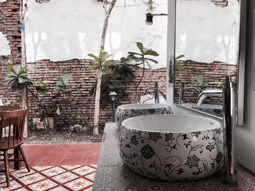 
a bath tub sitting in front of a window at Swiss Hotel Heritage Boutique Melaka in Malacca
