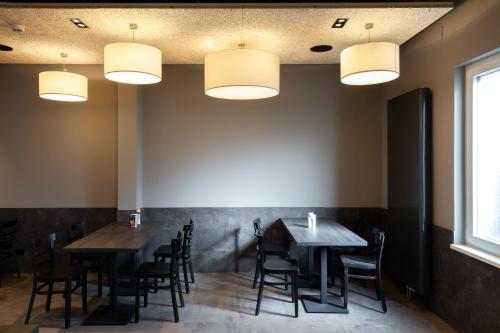 a dining room with tables and chairs and lights at a&o Frankfurt Ostend in Frankfurt/Main