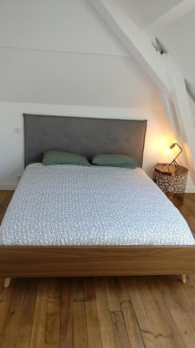 Cette chambre comprend un grand lit et du parquet. dans l'établissement Le Rooftop des Halles, à Biarritz