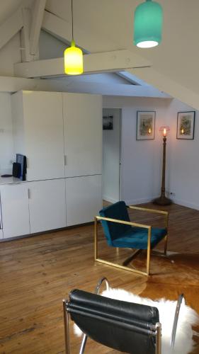 une chambre avec une chaise bleue et une table dans l'établissement Le Rooftop des Halles, à Biarritz