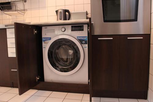 ハイドゥソボスローにあるIldikó Apartmanの電子レンジ付きのキッチン(洗濯機付)