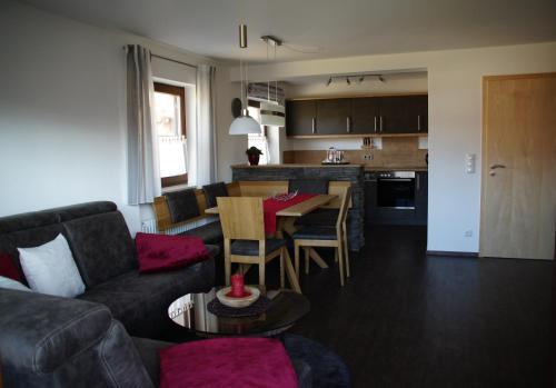 a living room and kitchen with a couch and a table at Ferienwohnungen Ellen Müller in Fischen