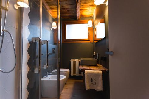 baño con lavabo y aseo y ventana en Granuit room & breakfast, en Sauze di Cesana