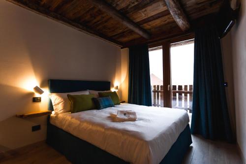 a bedroom with a large bed with a large window at Granuit room & breakfast in Sauze di Cesana