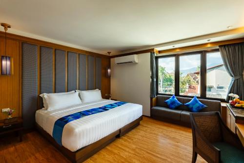 1 dormitorio con 1 cama grande y 1 sofá en Lavana Hotel Chiangmai, en Chiang Mai