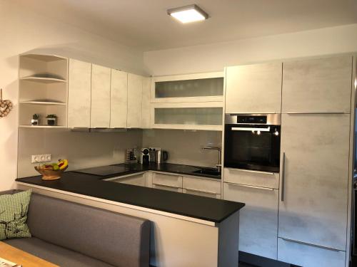 a kitchen with white cabinets and a stainless steel refrigerator at Am Holzmeisterweg 31 "Welzis" in Gosau