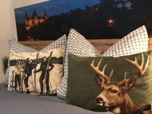 a group of pillows on a bed with a picture of a deer at Am Holzmeisterweg 31 "Welzis" in Gosau