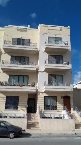 un edificio con balcones y un coche aparcado delante de él en Ullswater No. 9, en Marsaskala