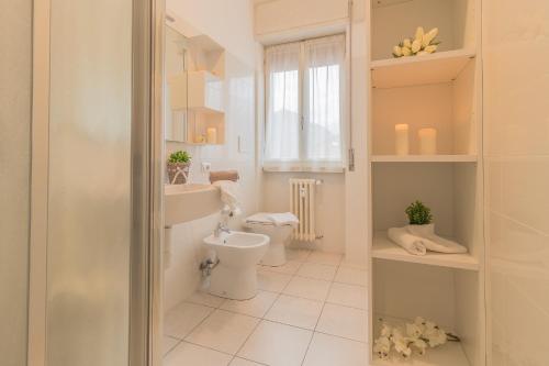 ein Badezimmer mit Toilette und Waschbecken und einem Fenster in der Unterkunft Alexis House Varenna in Varenna