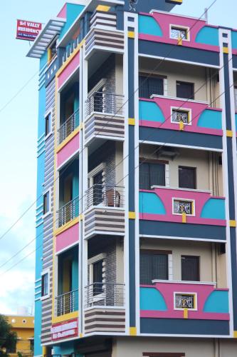 a tall apartment building with colorful balconies at Sri Vally Residency in Kālapettai