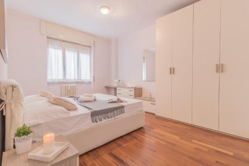 ein weißes Schlafzimmer mit weißen Schränken und einem Bett in der Unterkunft Alexis House Varenna in Varenna