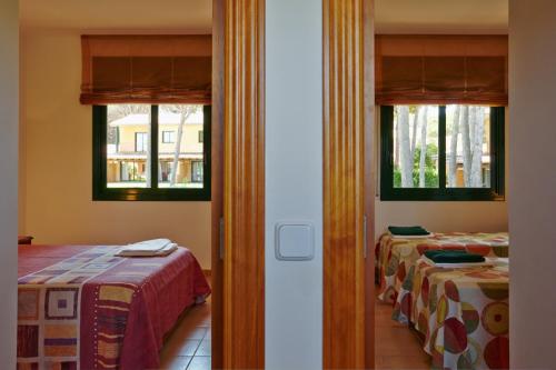 two beds in a room with two windows at Casas Golf Relax in Pals