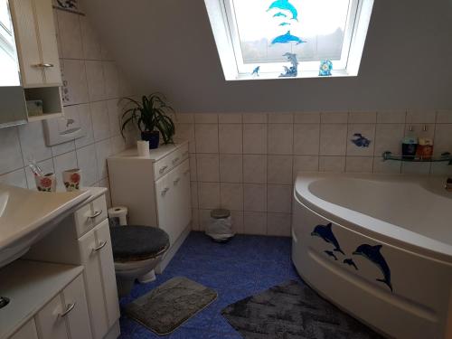 a bathroom with a sink and a tub and a window at Susi"s Ferienwohnungen in Wermelskirchen