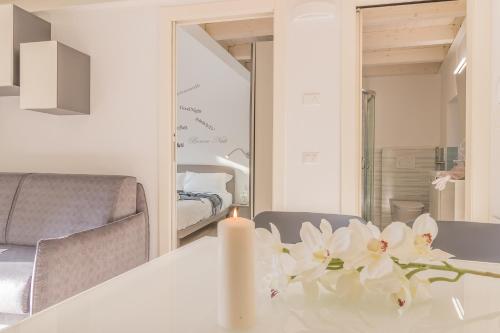 a white table with a candle and flowers on it at Pretty Home Varenna in Varenna