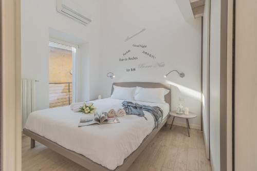 a bedroom with a white bed with books on it at Pretty Home Varenna in Varenna