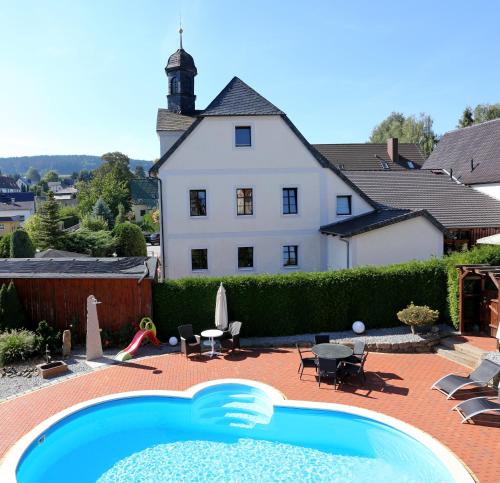 a house with a swimming pool in front of a house at Landhotel Thürmchen in Schirgiswalde