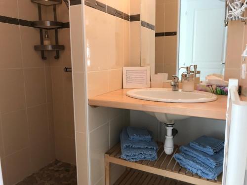 a bathroom with a sink and a mirror and towels at Joussac Côté Plage - Devant l'océan in Soulac-sur-Mer
