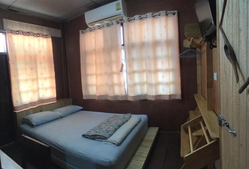 a small bed in a small room with windows at ซอยห้า โฮมสเตย์ เชียงคาน in Chiang Khan