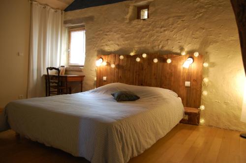 a bedroom with a large bed with lights on it at Chambre d'hôte et gîte de Cantagrel in Saint-Cirq-Lapopie