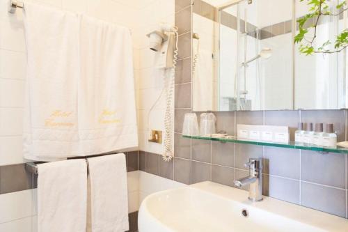 a bathroom with a sink and a mirror and towels at Hotel Cacciani in Frascati