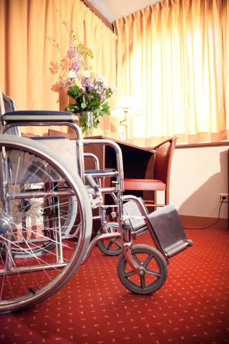 a wheelchair parked in a room with a piano at Au Feu de Bois in Amou