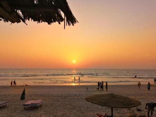 a group of people on the beach at sunset at Elegant Shades in Colva