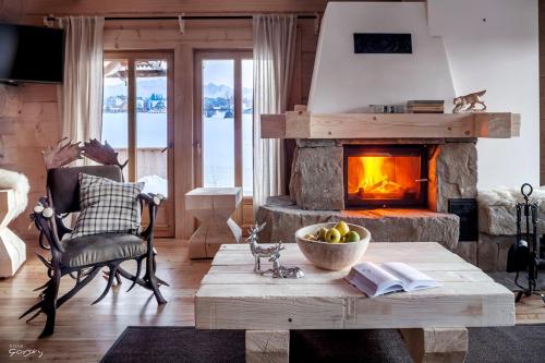 a living room with a table and a fireplace at Luxury Chalet Villa Gorsky in Poronin