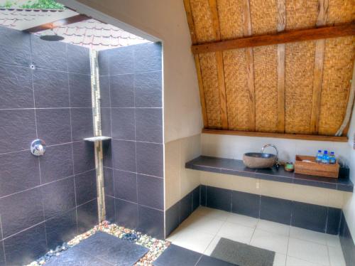 a bathroom with a shower with blue tiles at Chill Out Bungalows in Gili Air