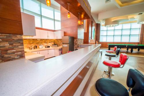 a bar in a large room with red chairs at Centaurus Hotel Suites in Islamabad