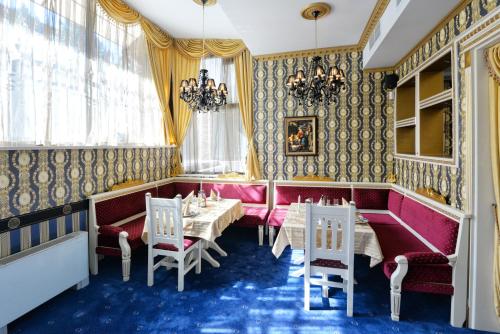 a dining room with tables and chairs and a chandelier at Hotel Boyana - Free Parking in Sofia