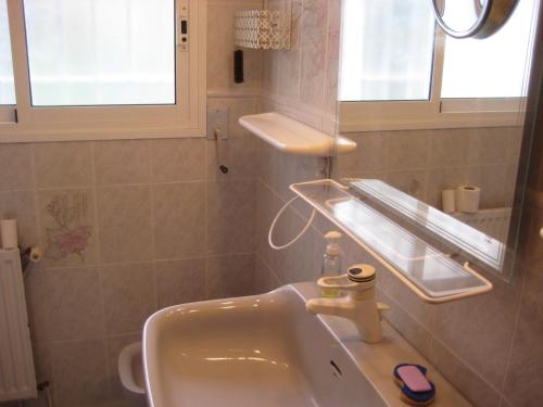 a bathroom with a sink and a window and a mirror at Almeria 3 in Roses