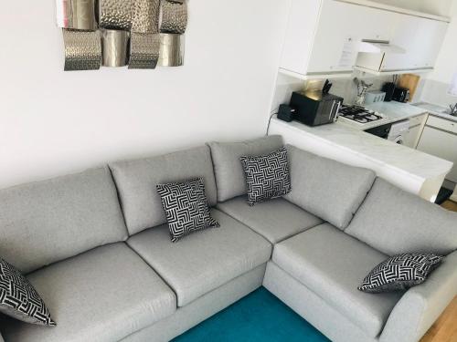 a living room with a gray couch with pillows at Arma Short Stays 46 Bicester - Sleeps 3 - Free Parking & Garden in Bicester