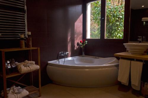 a bathroom with a bath tub and a window at Hotel Resort Cueva del Fraile in Cuenca