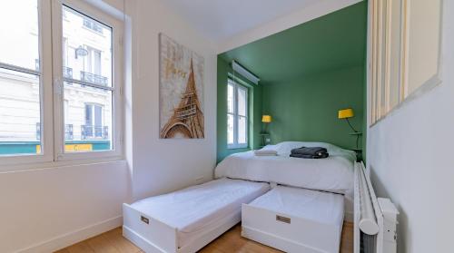 - une chambre avec 2 lits et un mur vert dans l'établissement Midoon guest - DUPLEX D'ARCHITECT PARIS 10ème, à Paris