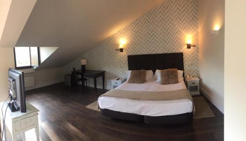 a bedroom with a large bed in a attic at Hotel Resort Cueva del Fraile in Cuenca