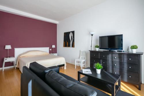 a living room with a couch and a bed and a tv at Culture Residence Consalvo Otto in Naples