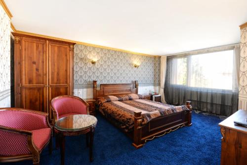 a bedroom with a bed and two chairs at Hotel Boyana - Free Parking in Sofia