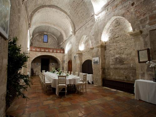 a dining room with tables and chairs in a building at Garrigae Abbaye de Sainte Croix in Salon-de-Provence
